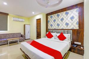 a bedroom with a large bed with red pillows at OYO Hotel Golden in Vadodara