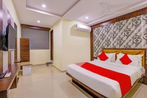 a bedroom with a large bed with red pillows at Super OYO Hotel Golden in Vadodara