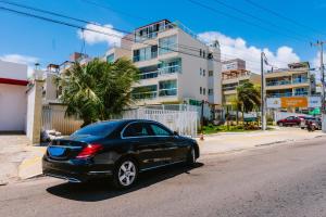 une voiture noire garée sur le côté d'une rue dans l'établissement APART Alto padrao praia PIRANGI, à Parnamirim