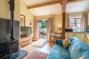 uma sala de estar com um sofá azul e um fogão em Todd Cottage - Ideal for exploring Wasdale & Wastwater em Santon Bridge