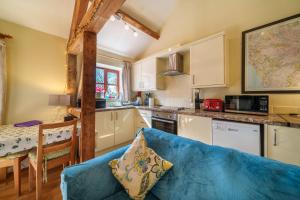 a living room with a blue couch in a kitchen at Todd Cottage - Ideal for exploring Wasdale & Wastwater in Santon Bridge