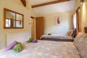 a bedroom with two beds and a mirror at Todd Cottage - Ideal for exploring Wasdale & Wastwater in Santon Bridge