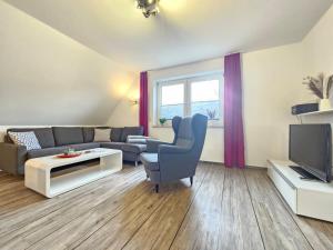 a living room with a couch and a tv at Mienhus Apartments Ferienwohnung Famke in Norden