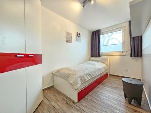 a small bedroom with a bed and a window at Mienhus Apartments Ferienwohnung Famke in Norden
