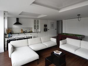 Suite Sixteen Szafarnia في غدانسك: غرفة معيشة مع كنبتين وطاولة بلياردو