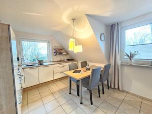a kitchen with a table and chairs in a room at Mienhus Apartments Ferienwohnung Jantje in Norden