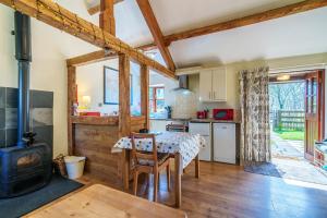 a kitchen and dining room with a table and a stove at Gunn Cottage - Dog-friendly enclosed garden in Santon Bridge