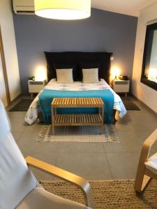 una camera con un letto con una panca e due lampade di Gite-Grand studio contemporain proche Toulouse dans domaine Equestre a Bouloc