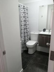 a bathroom with a toilet and a shower curtain at Hermoso departamento in Coquimbo