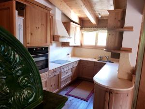 a kitchen with wooden cabinets and a stove top oven at Family and Wellness Residence Ciasa Antersies in San Cassiano