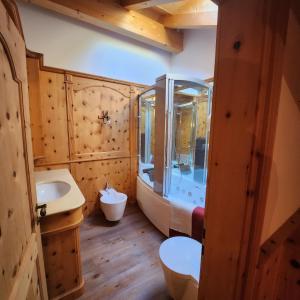 een badkamer met een bad en een wastafel bij Family and Wellness Residence Ciasa Antersies in San Cassiano