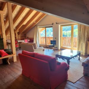 a living room with red couches and a table at Family and Wellness Residence Ciasa Antersies in San Cassiano
