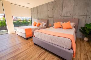 two beds with orange pillows in a room at KUKO SUITES in Chilpancingo de los Bravos