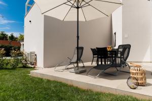 - une table et des chaises sous un parasol sur la terrasse dans l'établissement Costa Premium, à Funtana
