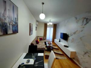 un soggiorno con un divano e un tavolo di New York - Central Point a Podgorica