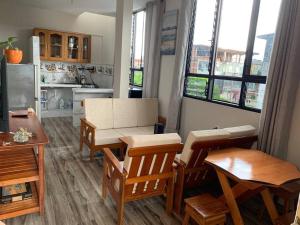 una sala de estar con sillas y una cocina con ventanas en Departamento a 3 cuadras de la plaza principal, en Puerto Maldonado