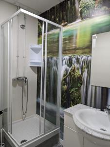 baño con ducha y una pintura de una cascada en Hoomy en Murcia