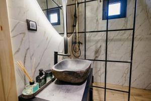 ein Badezimmer mit einem Steinwaschbecken auf der Theke in der Unterkunft Azalea Chalet in Divčibare