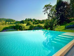 una grande piscina blu con vista sugli alberi di Das Rizzi 