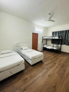 Elite Stays Viman nagar في بيون: سريرين في غرفة ذات أرضيات خشبية