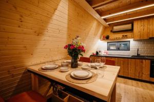 a dining room with a table with a vase of flowers at Azalea Chalet in Divčibare
