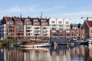 a group of boats docked in a harbor with buildings at Suite Sixteen Szafarnia in Gdańsk