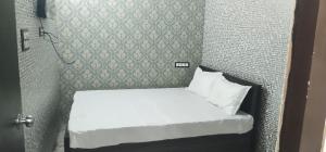 kolkataにあるHOTEL BLUE MOONの壁のある小さな部屋の小さなベッド1台分です。