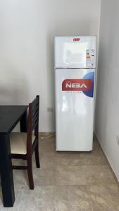 a white refrigerator in a room next to a table at BADAWI in San Fernando del Valle de Catamarca