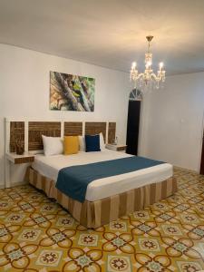 a bedroom with a large bed with a chandelier at FINCA VILLA ESMERALDA in Pereira