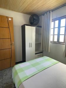 1 dormitorio con 1 cama, armario y ventana en residencia bem viver, en Arraial do Cabo