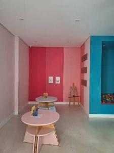 a room with two tables and a colorful wall at Studio Laguna 380 in Sao Paulo