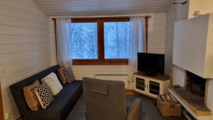 sala de estar con sofá y TV en Lomariihi 6, en Jyväskylä