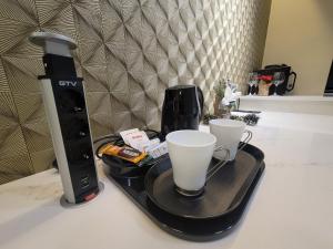 bandeja con dos tazas de café en una barra en La Mirage Suites & Apartments en Tirana