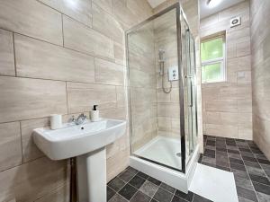 ein Bad mit einem Waschbecken und einer Dusche in der Unterkunft Bright and Airy Studio in Trendy Birmingham Locale in Birmingham