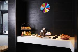 a shelf with fruits and vegetables on a black wall at Hôtel Alt Montréal in Montréal