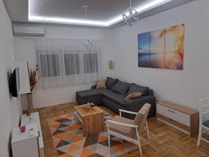 a living room with a couch and a table at Apartman Talija in Valjevo +10 photos