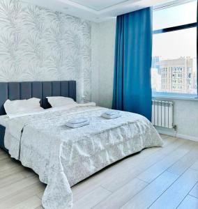 ein Schlafzimmer mit einem Bett und einem großen Fenster in der Unterkunft G-home apartments in Expo New life-2 in Astana