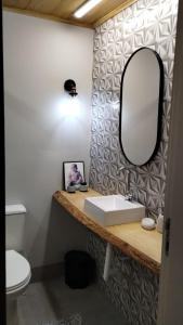 uma casa de banho com um lavatório e um espelho em Aps de frente com sacada ou terraço a 10 minutos do Aeroporto em Porto Alegre