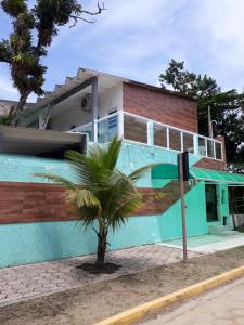 una casa con una palmera delante de ella en CASA DO PESCADOR en Peruíbe