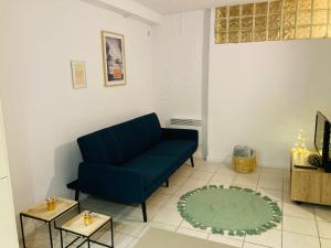 - un salon avec un canapé bleu et un tapis dans l'établissement Village apartment with character, à Saint-Hippolyte