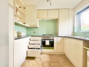 a kitchen with white cabinets and an oven at Peacock Court in London