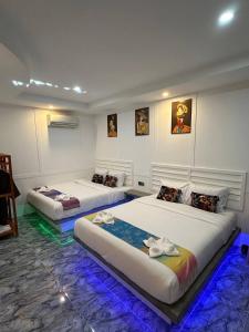 two beds in a room with blue lights at SEA SAND RESORT in Kampot