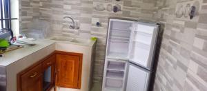 uma cozinha com um lavatório e um frigorífico aberto em Appartement meublé deux chambres salons em Cotonou