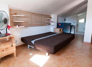 a bedroom with a bed and a desk and a fan at Jabia Beach House in Marinella di Selinunte