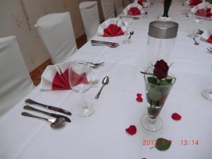 Hotel Restaurant Jonkhans في ريز: طاولة مع قطعة قماش بيضاء مع الورود والأكواب