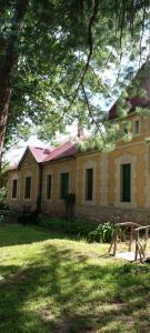 a large yellow building with a tree in front of it at Cabaña en quinta la aurora in Mina Clavero