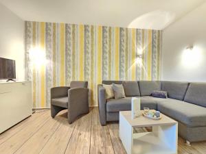 a living room with a couch and a chair at Mienhus Apartments Ferienwohnung Beeke in Norden