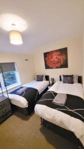 a room with two beds and a television in it at Three Bed House with free on-site parking Sleeps 5 in Warrington