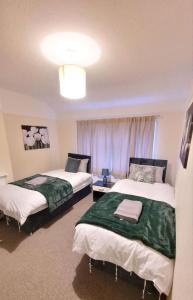 Habitación con 2 camas y lámpara de araña. en Three Bed House with free on-site parking Sleeps 5 en Warrington