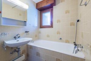 a bathroom with a sink and a bath tub at Arnica 1 - 6 pers - piscine in Nendaz +20 photos